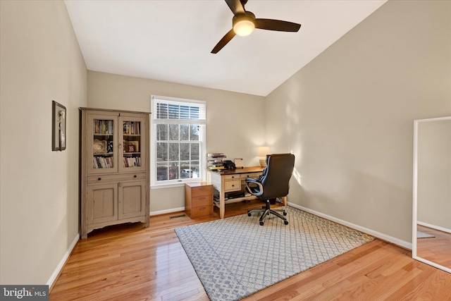 office space featuring visible vents, baseboards, lofted ceiling, ceiling fan, and light wood-style floors