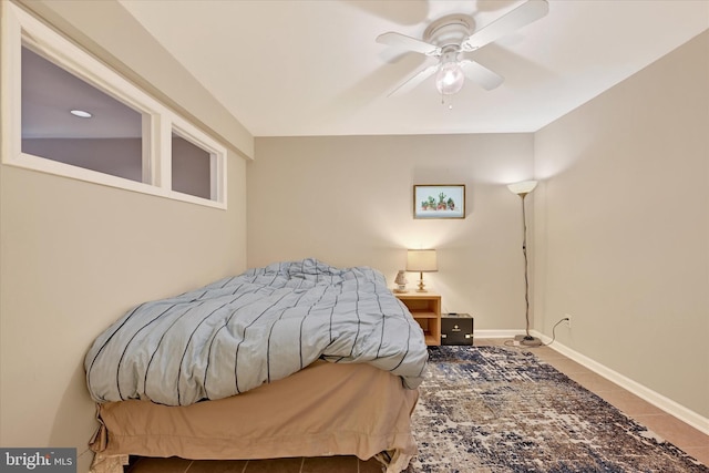 tiled bedroom featuring ceiling fan and baseboards