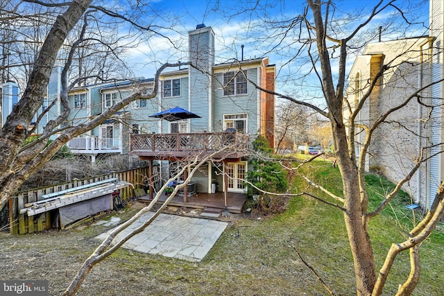 back of house featuring a chimney and a deck