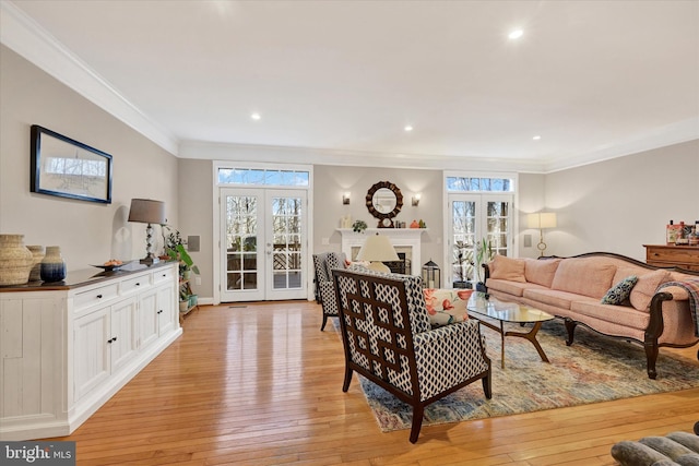 living room featuring ornamental molding, a wealth of natural light, french doors, and light wood-style flooring