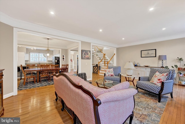 living area with light wood finished floors, baseboards, stairway, crown molding, and recessed lighting