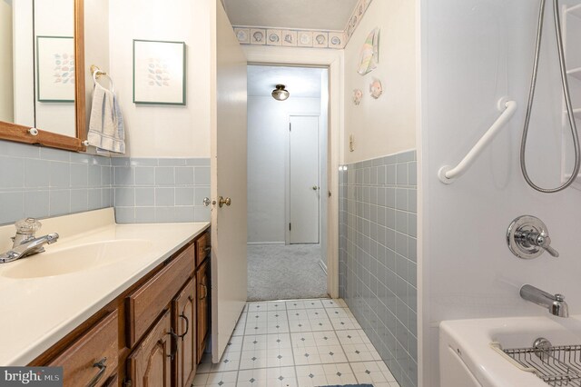 full bathroom featuring tile patterned floors, tile walls, bathtub / shower combination, and vanity