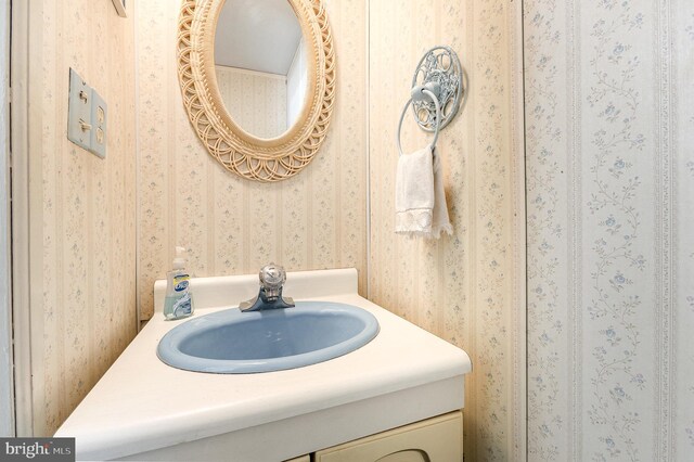 bathroom with vanity and wallpapered walls