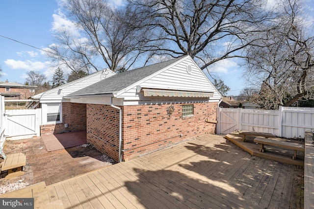 wooden terrace with a patio, a fenced backyard, and a gate