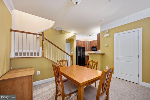 dining space featuring crown molding, visible vents, stairway, light carpet, and baseboards