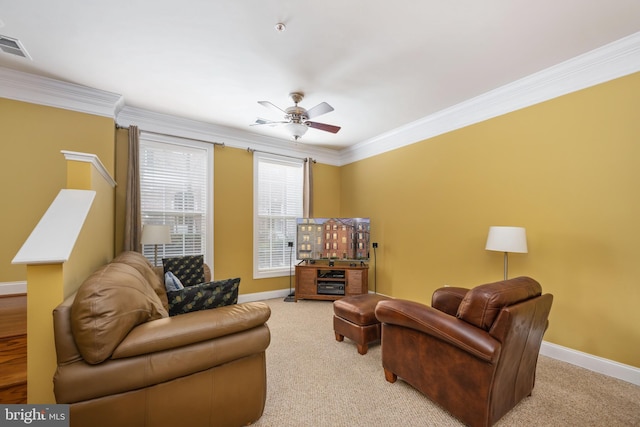 living area featuring light carpet, baseboards, ornamental molding, and ceiling fan