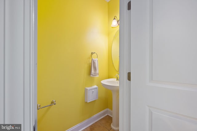 bathroom featuring baseboards, a sink, and tile patterned floors