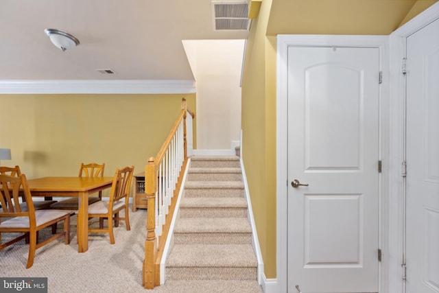 staircase with baseboards, visible vents, and crown molding