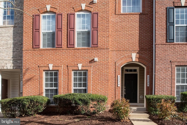 entrance to property featuring brick siding