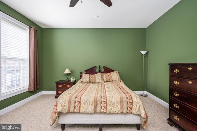 carpeted bedroom with ceiling fan and baseboards