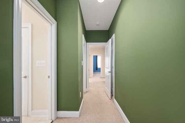 hallway with light carpet and baseboards