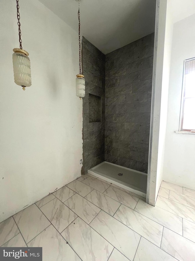 bathroom featuring a stall shower and marble finish floor