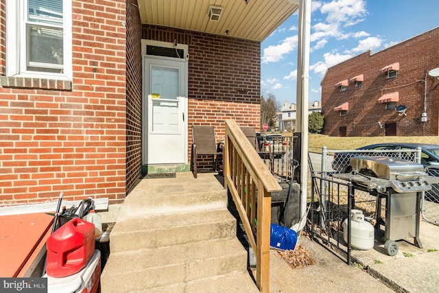 entrance to property featuring brick siding