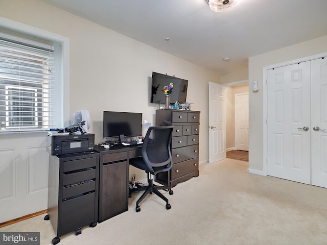 office space featuring light carpet and baseboards