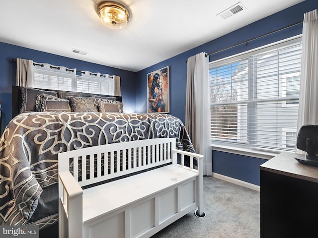 bedroom featuring multiple windows, visible vents, and carpet flooring