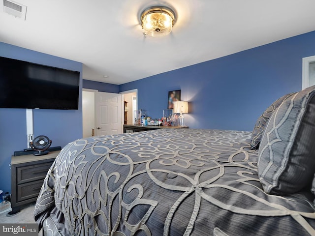 carpeted bedroom featuring visible vents