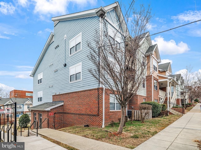 view of side of property with a residential view and brick siding