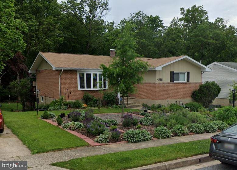 ranch-style home featuring brick siding, a chimney, and a front lawn