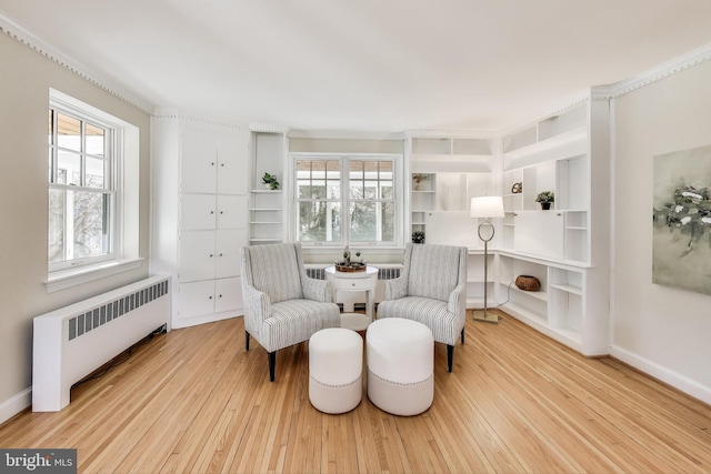 living area featuring a wealth of natural light, hardwood / wood-style floors, and radiator heating unit