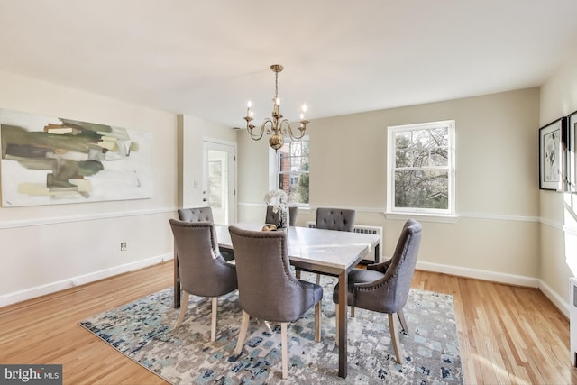 dining area with an inviting chandelier, baseboards, and wood finished floors