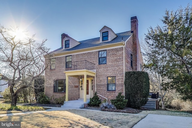 view of front of home featuring brick siding and a chimney