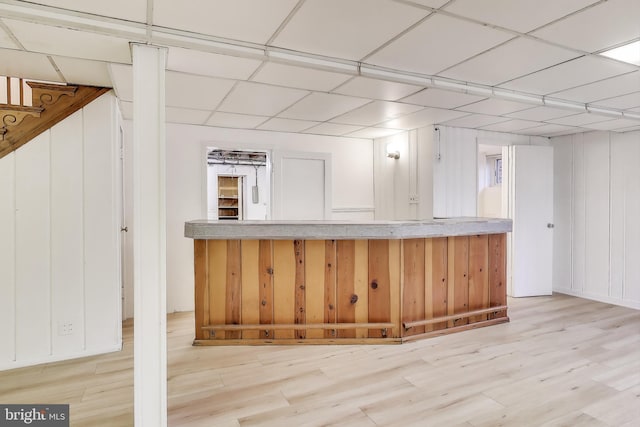 bar featuring a paneled ceiling and light wood finished floors