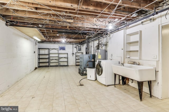 unfinished below grade area with light floors, a heating unit, electric water heater, and washer and dryer