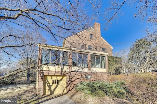 exterior space featuring brick siding and a chimney