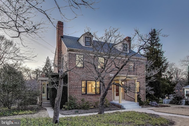 view of front of property with brick siding and a chimney