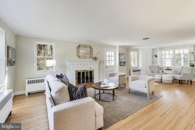 living room featuring radiator heating unit and light wood-style flooring