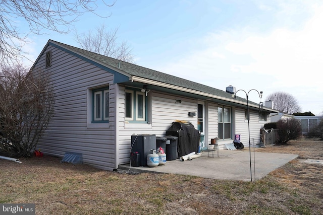 rear view of property featuring a patio area and roof with shingles