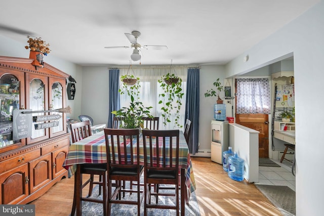 dining room with a baseboard heating unit and ceiling fan