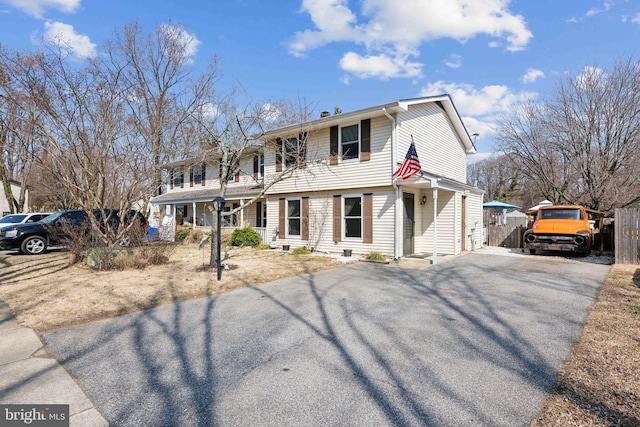 view of front of property featuring aphalt driveway and fence