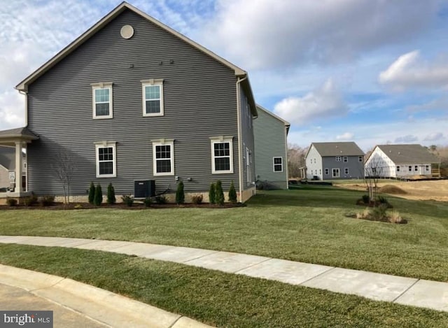 view of side of home with a yard and central AC unit