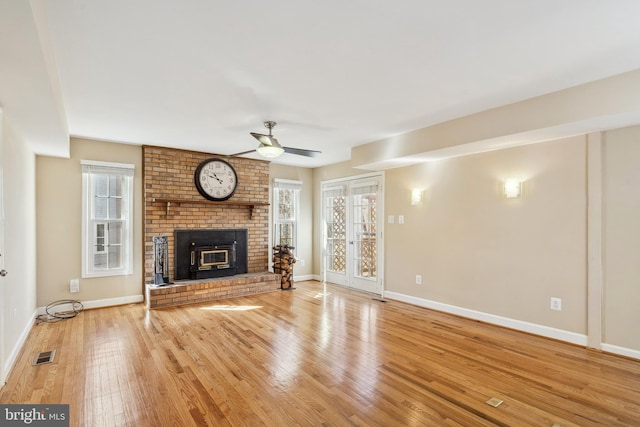 unfurnished living room with a wealth of natural light, visible vents, a fireplace, and wood-type flooring