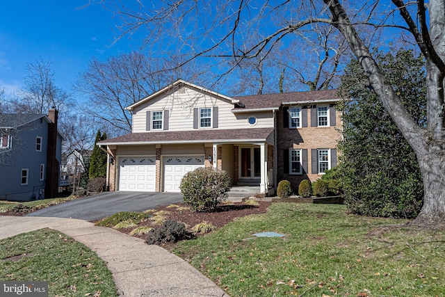 traditional-style home featuring roof with shingles, an attached garage, a front lawn, aphalt driveway, and brick siding