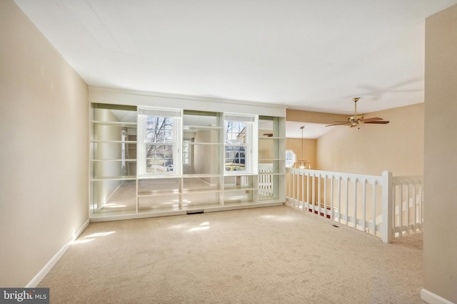 empty room featuring visible vents, baseboards, carpet, and a ceiling fan