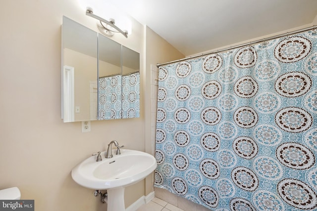 full bath featuring curtained shower, tile patterned floors, and a sink