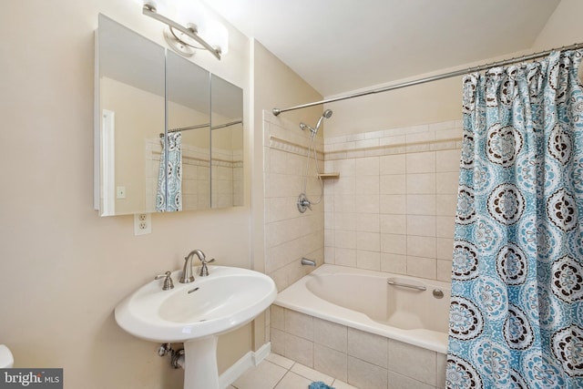 bathroom with tile patterned floors, shower / bath combo with shower curtain, and a sink