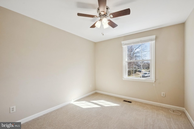 spare room with carpet flooring, baseboards, visible vents, and a ceiling fan