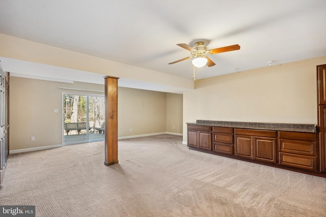 interior space with light colored carpet, a ceiling fan, and baseboards