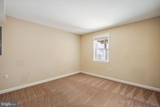 carpeted spare room with baseboards