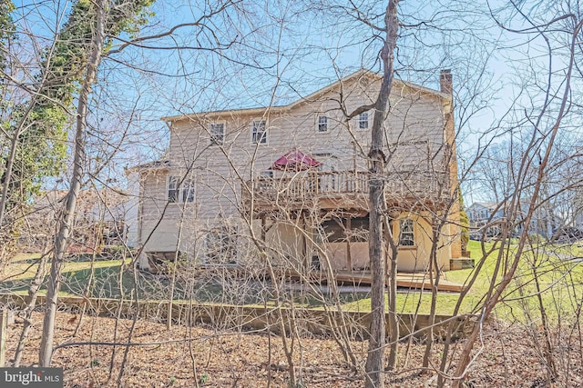 back of house featuring a chimney