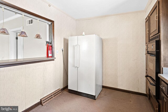 kitchen featuring carpet floors, visible vents, freestanding refrigerator, and ornamental molding