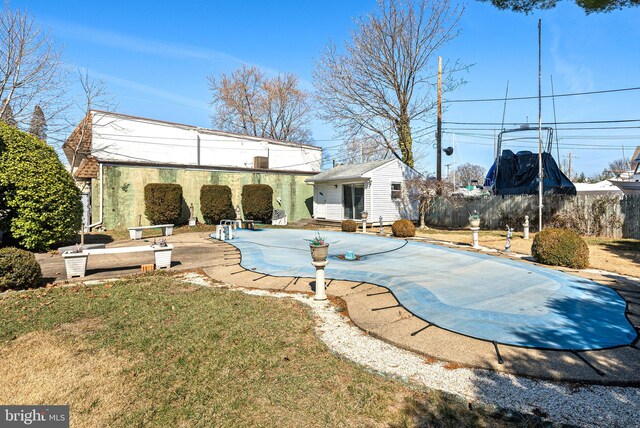 rear view of house featuring a lawn, a patio, an outdoor structure, and fence