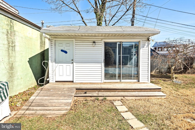 property entrance featuring a lawn and fence