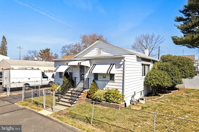 bungalow-style home featuring a gate, a fenced front yard, aphalt driveway, a front yard, and a chimney