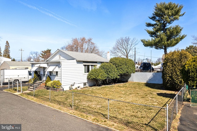 view of side of home featuring a fenced front yard and a yard