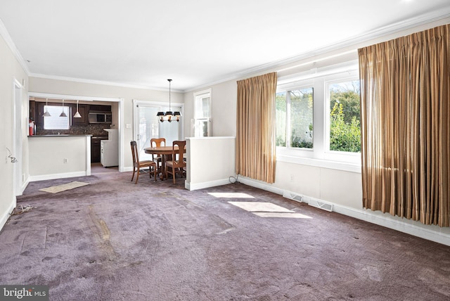 unfurnished living room featuring visible vents, baseboards, carpet, a chandelier, and ornamental molding