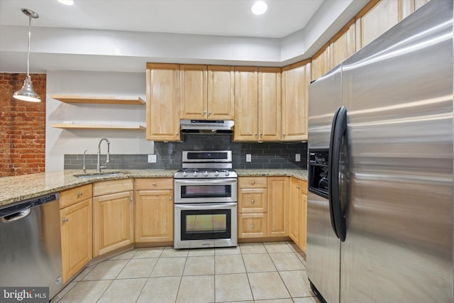 kitchen featuring under cabinet range hood, a sink, tasteful backsplash, stainless steel appliances, and light stone countertops